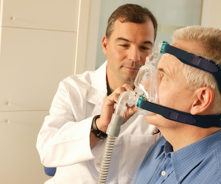 Doctor and sleep apnea patient with CPAP device
