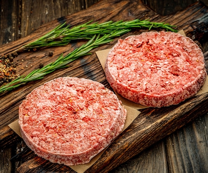 4 nicely arranged raw chicken legs lying next to each other