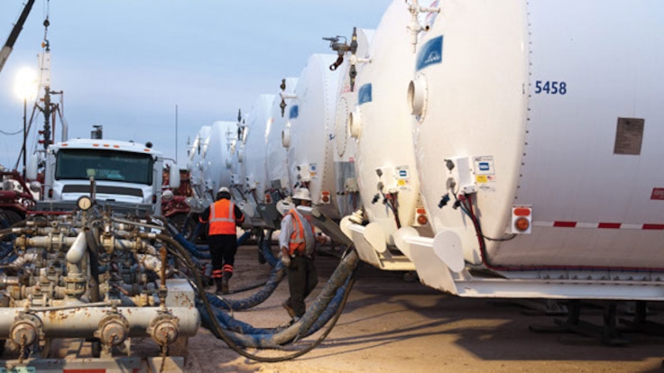 View of multiple Linde trucks piped for foam fracturing at an oilfield