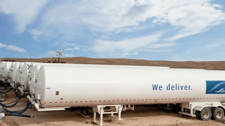 View of multiple Linde portable nitrogen storage trailers piped for foam fracturing at an oil field