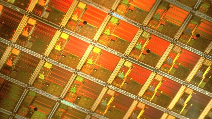 Close up of an orange-colored semiconductor wafer.
